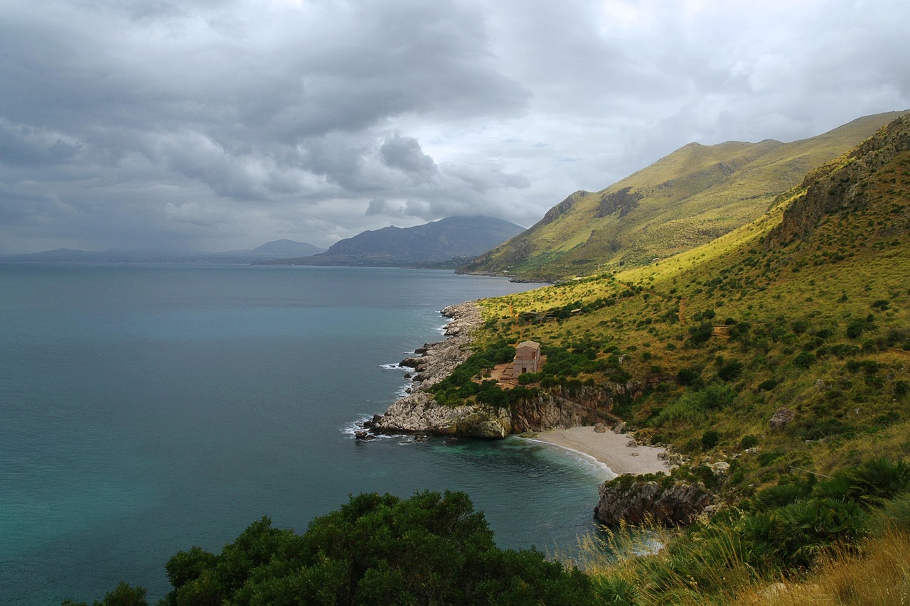 Panorama mozzafiato di un paese sardo con case colorate e natura incontaminata, simile a un set cinematografico.