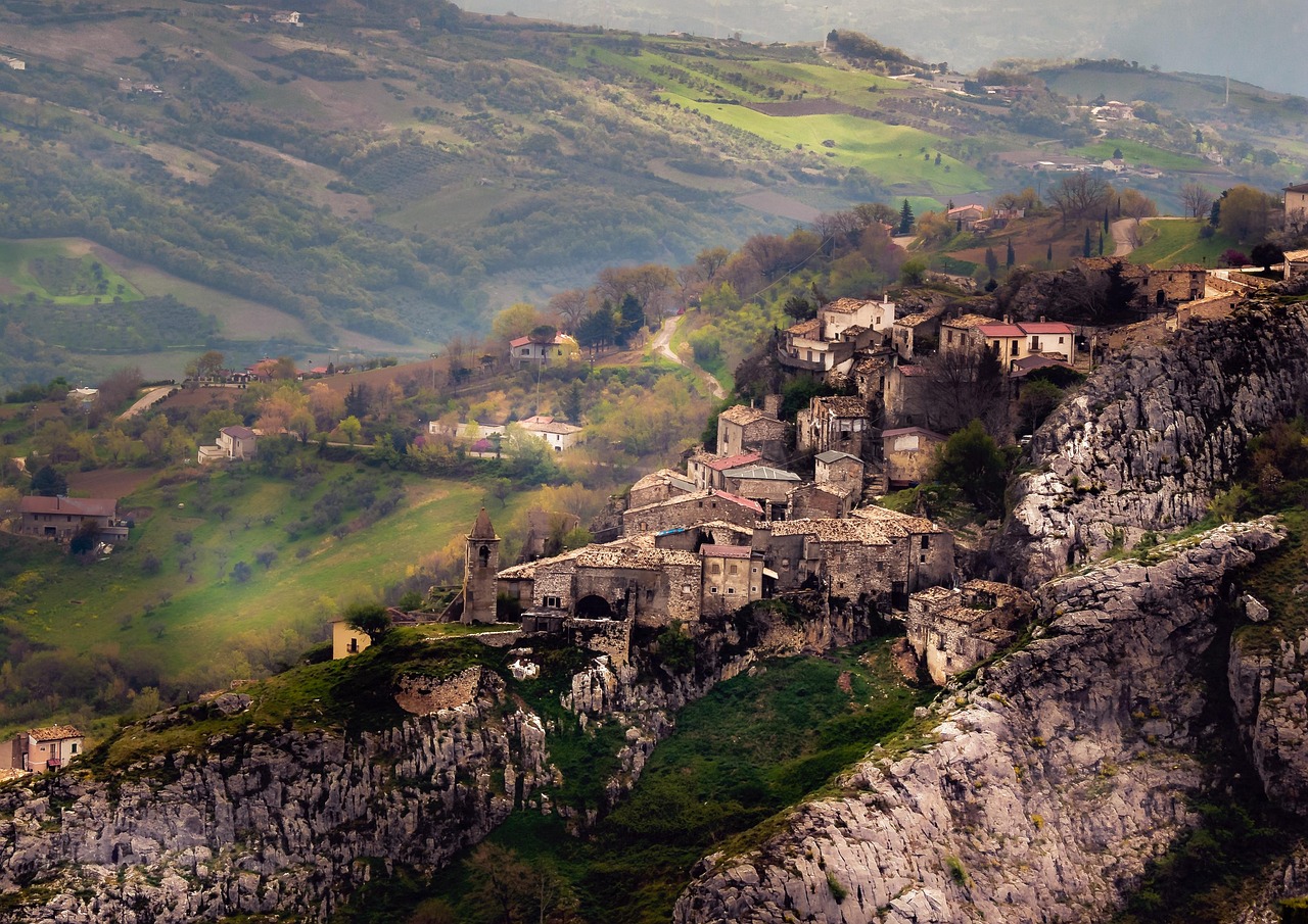 Panorama del borgo lucano con case in pietra e colline verdi sullo sfondo.