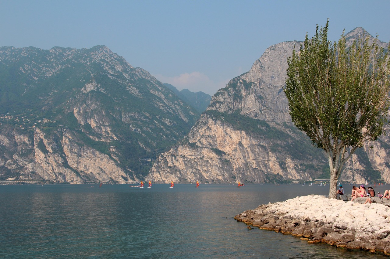Lago italiano che ricorda un fiordo norvegese, circondato da montagne verdi e acque blu.