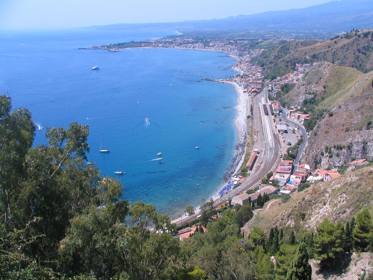 Spiaggia calabrese con sabbia bianca e acque cristalline, ideale per una vacanza estiva.