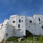 Panorama del pittoresco paese pugliese, con case bianche e strade acciottolate, ideale per i viaggiatori.