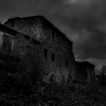 Villaggio abbandonato in Liguria, con antiche case e vegetazione, simbolo di storia e mistero.