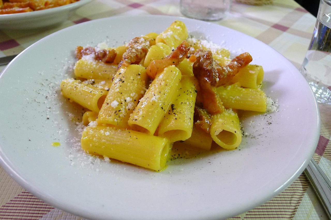 Piatto di carbonara fumante servito in un ristorante romano, con guanciale croccante e pecorino.