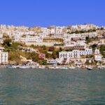 Panorama di un'isola italiana con spiagge, mare azzurro e vegetazione lussureggiante, ideale per l'estate.