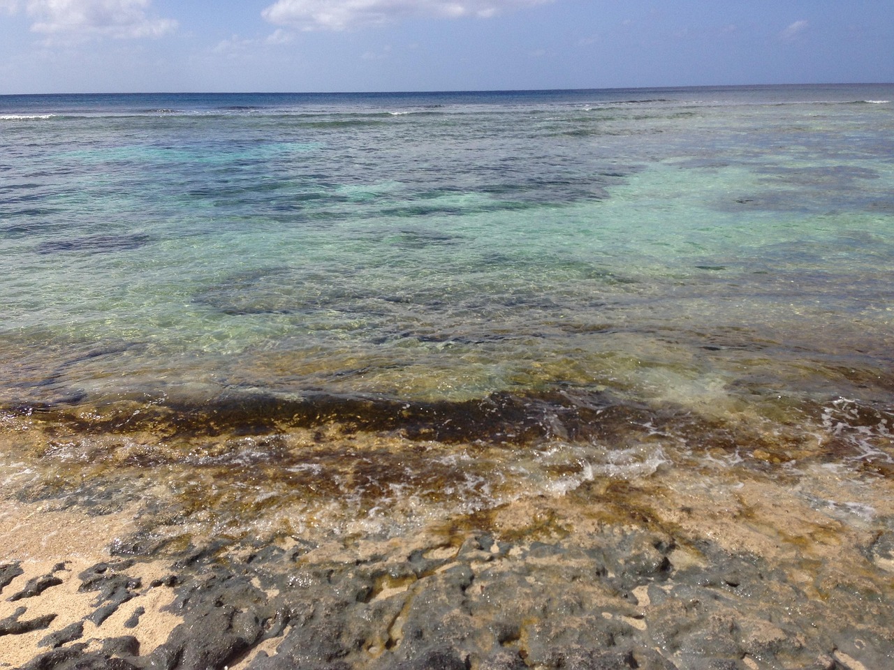 Baia con acque che cambiano colore, vista panoramica suggestiva al tramonto.