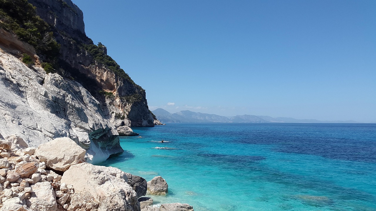 Spiaggia segreta della Sardegna con acque cristalline e sabbia bianca, immersa nella natura.