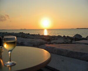 Terrazza panoramica in Sardegna con vista sul mare dorato al tramonto.