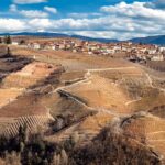 Panorama mozzafiato del paese piemontese tra colline verdi e cieli sereni.