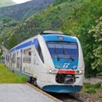 Treno che attraversa paesaggi montani innevati sulla ferrovia transiberiana d'Italia.