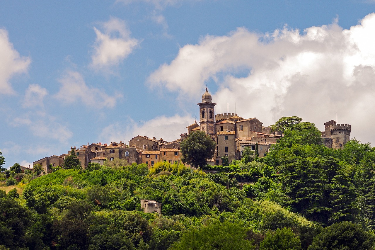 Vista panoramica del borgo toscano, con case in pietra e colline verdi sullo sfondo.