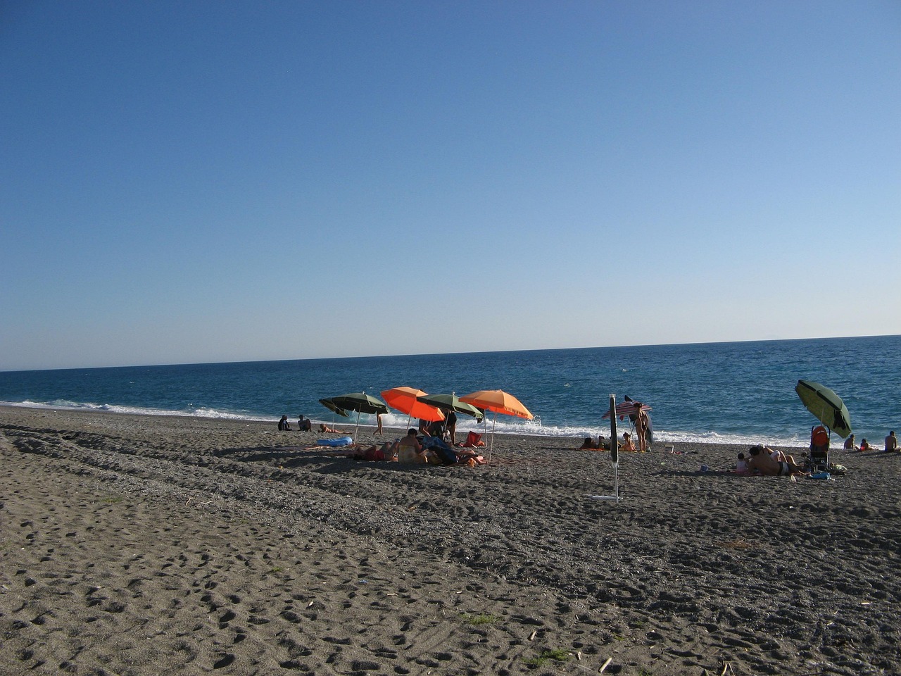 Spiaggia calabrese con sabbia bianca e acque cristalline, ideale per una visita estiva.