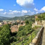 Borgo in Piemonte con vista panoramica sulle colline circostanti e il cielo azzurro.
