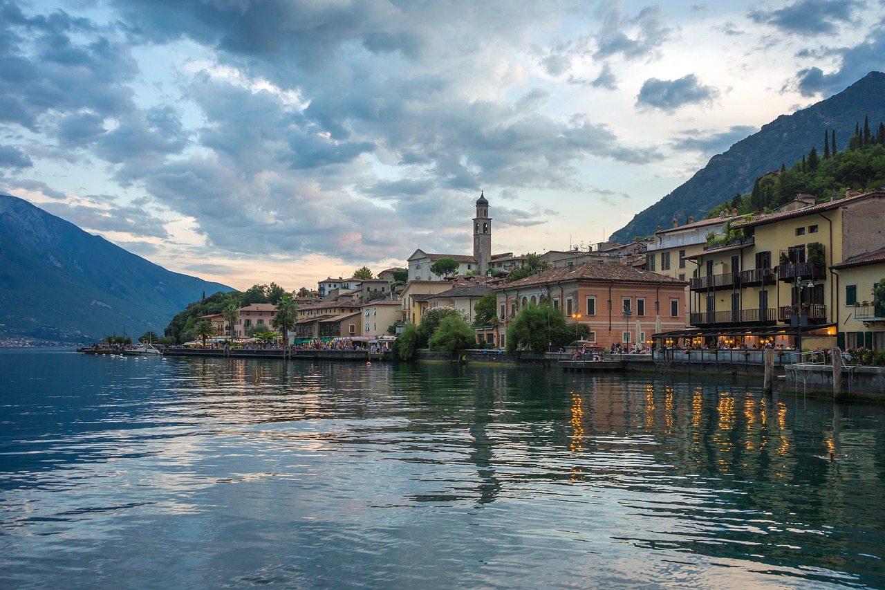Lago italiano con acque cristalline e colori vivaci, simile a un dipinto.