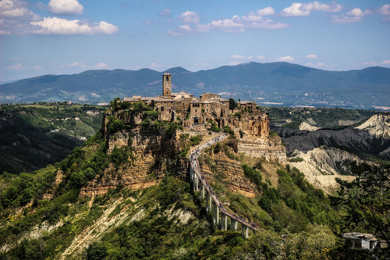 Vista panoramica del pittoresco paese marchigiano, con case colorate e colline verdi.